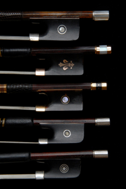 Violin, viola and cello bows on a black background