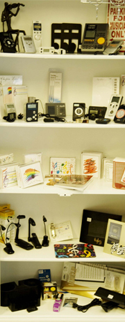 Shelf of violin accessories and gifts including metronomes, music lights and cards